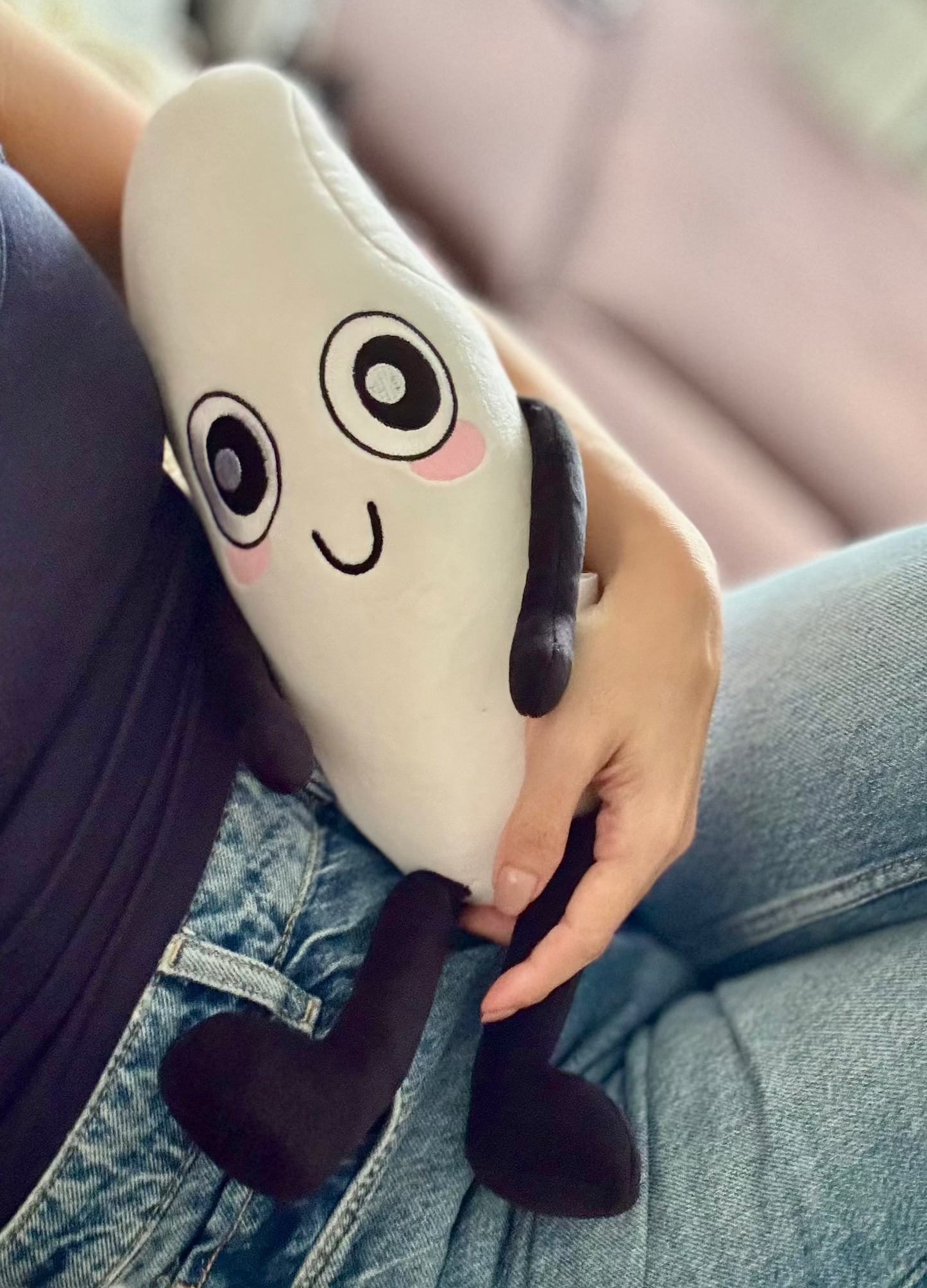 Person holding a plush grain of rice toy with a friendly face