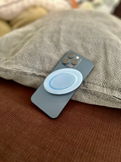 Phone with a blue plate pop socket on a textured surface